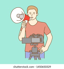 Camera recording a young male blogger talking while making a video