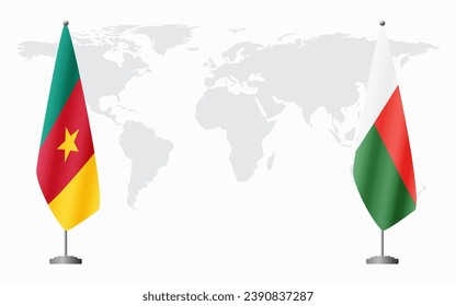 Cameroon and Madagascar flags for official meeting against background of world map.