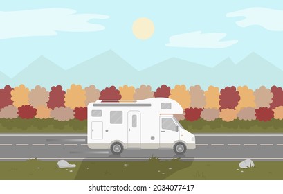 A camper or a caravan is driving on a motorway on autumn background.