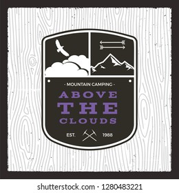 Camping adventure monochrome card. Above the clouds quote with mountains, eagle and arrows. Wildlife Explorer Badge and patch Nice for t-shirt, mug, poster, other print. Stock vector illustration.