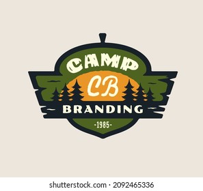 Camping Logo Emblem Concept. Fir Spruce Tree Sun Icon Great Outdoors Symbol. Forest Camp Lover Icon Sign. Wild Woods Adventure Design. Acorn Shape Badge Wooden Elements