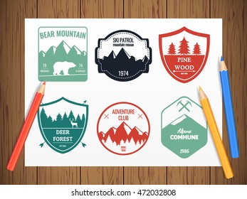 Camping and outdoors adventure vintage logos, emblems, badges set on realistic wooden background. Silhouettes and design elements. Vector illustration