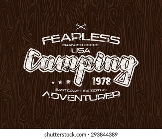 Camping typographic emblem with shabby texture. Graphic design for t-shirt. White print on wood texture background