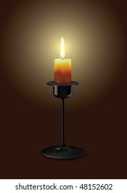 Candle in a candlestick lit in the dark