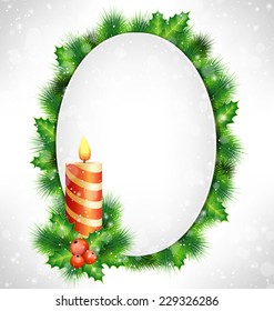 Candle, holly sprigs and pine branches with grayscale blank oval frame in snowfall on grayscale background