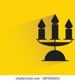 candle with shadow on yellow background