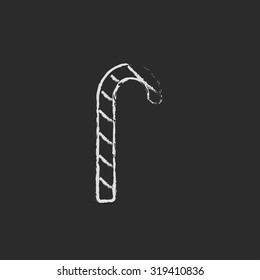Candy cane hand drawn in chalk on a blackboard vector white icon isolated on a black background.