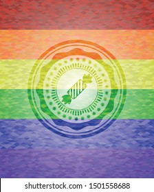 candy icon inside emblem on mosaic background with the colors of the LGBT flag