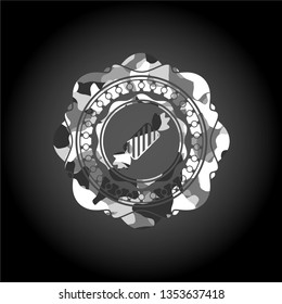 candy icon inside grey camouflaged emblem