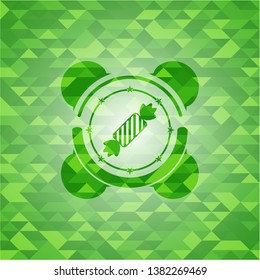 candy icon inside realistic green mosaic emblem