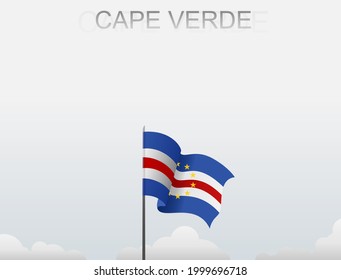 The Cape Verde flag flutters on a pole that stands tall against a white sky