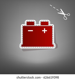 Car battery sign. Vector. Red icon with for applique from paper with shadow on gray background with scissors.
