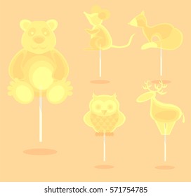 Caramel yellow candy on a stick in the form of cartoon forest animals. For children on holidays