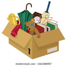A cardboard box filled with various household junk items