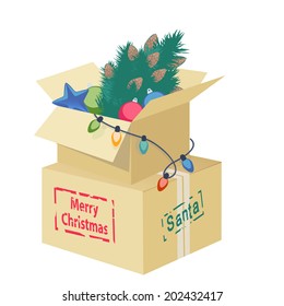 Cardboard box overflowing with Christmas decorations with an eggshell, Christmas tree, ornaments and string of lights with the text - Merry Christmas