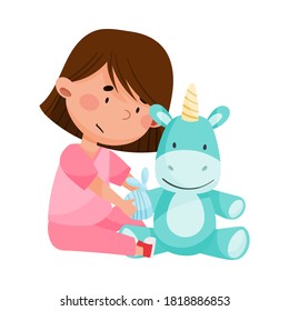 Careful Little Girl in Medical Wear Treating Fluffy Toy Unicorn Vector Illustration