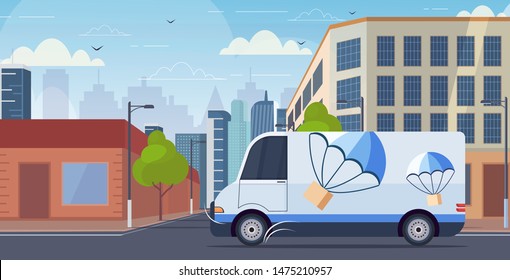 cargo van truck driving city road parcel box with parachute flying down from sky express delivery service concept modern cityscape background horizontal