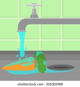 Carrot being cleaned and washed in a sink in a kitchen. Running tap water.