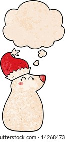 cartoon bear wearing christmas hat with thought bubble in grunge texture style