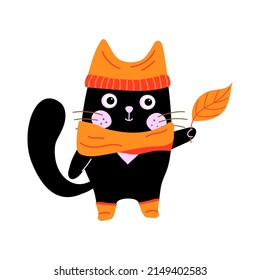 Cartoon black cat in a hat, scarf and boots with an orange autumn leaf in its paws. Cute fall character