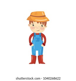 Cartoon character of young farmer in blue overall, red sweater, boots and straw hat. Little gardener. Smiling boy with shiny eyes and freckles on face. Flat vector design