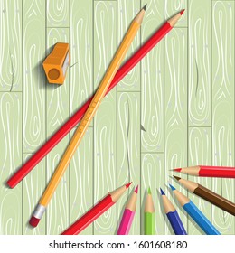 Cartoon color vector banner with pencils, sharpener on the wooden background