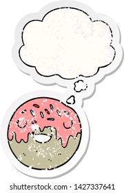 cartoon donut with thought bubble as a distressed worn sticker