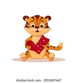 Cartoon festive little tiger sitting and holding a New Year's boot, sock. Year of the tiger.