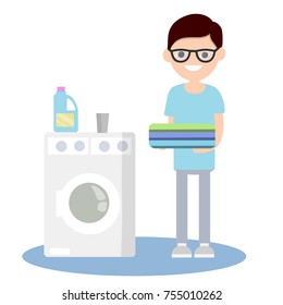 cartoon flat illustration - the guy with glasses in the blue dress with folded clothes in his hands next to a washing machine and detergent
