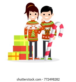 Cartoon flat illustration - New year's holidays. Two people - a guy and girl in warm winter Christmas sweater with the reindeer pattern. The mountain of gifts in boxes and a huge sweet lolly pop.