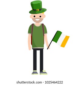 Cartoon flat illustration- a young bearded guy in green clothes and a hat stands with a flag. celebration of St. Patrick's. One man with a backpack.
