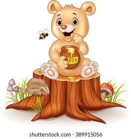 Cartoon funny baby bear holding honey pot on tree stump