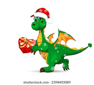 A cartoon green dragon walks wearing a Santa hat, holding a gift box in its paws. A green dino on a white background.