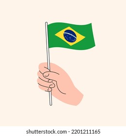 Cartoon Hand Holding Brasilian Flag Icon, The Flag of Brasil, Concept Illustration. Flat Design Isolated Vector.