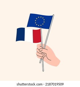 Cartoon Hand Holding European Union And French Flags. EU France Relationships. Concept of Diplomacy, Politics And Democratic Negotiations. Flat Design Isolated Vector