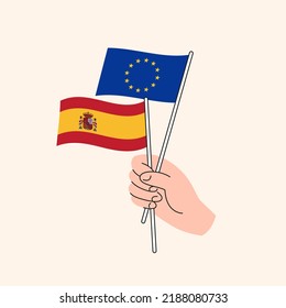 Cartoon Hand Holding European Union And Spanish Flags. EU Spain Relationships. Concept of Diplomacy, Politics And Democratic Negotiations. Flat Design Isolated Vector