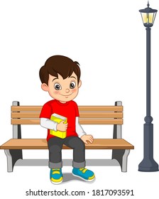 Cartoon happy boy sitting on bench with holding a books