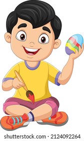 Cartoon little boy painting an easter egg