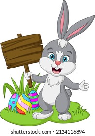 Cartoon little bunny holding a blank plank sign in the grass