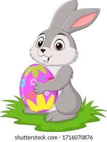 Cartoon little rabbit holding easter egg in the grass