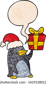 cartoon penguin with christmas present with speech bubble in retro texture style