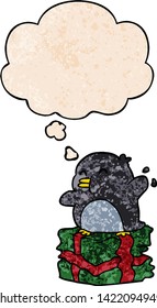 cartoon penguin on present with thought bubble in grunge texture style