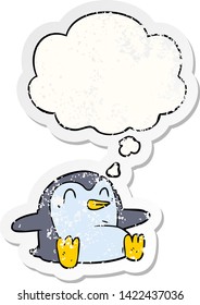 cartoon penguin with thought bubble as a distressed worn sticker