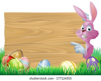 A cartoon pink Easter bunny rabbit peeping round a sign in green spring field full of chocolate decorated eggs