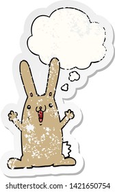 cartoon rabbit with thought bubble as a distressed worn sticker