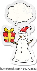 boneco de neve de desenho animado com presente com bolha de pensamento como um adesivo desgastado angustiado