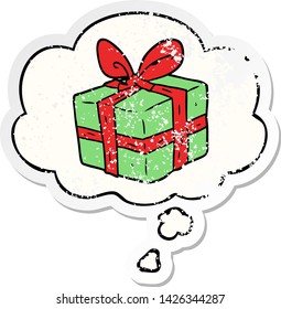Cartoon-verpacktes Geschenk mit Denkblase als bedrückter abgenutzter Aufkleber