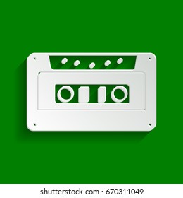 Cassette icon, audio tape sign. Vector. Paper whitish icon with soft shadow on green background.
