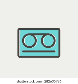 Cassette tape icon thin line for web and mobile, modern minimalistic flat design. Vector icon with dark grey outline and offset colour on light grey background.