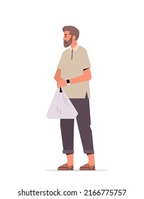 casual man with smart watch holding shopping plastic bag while walking vertical full length